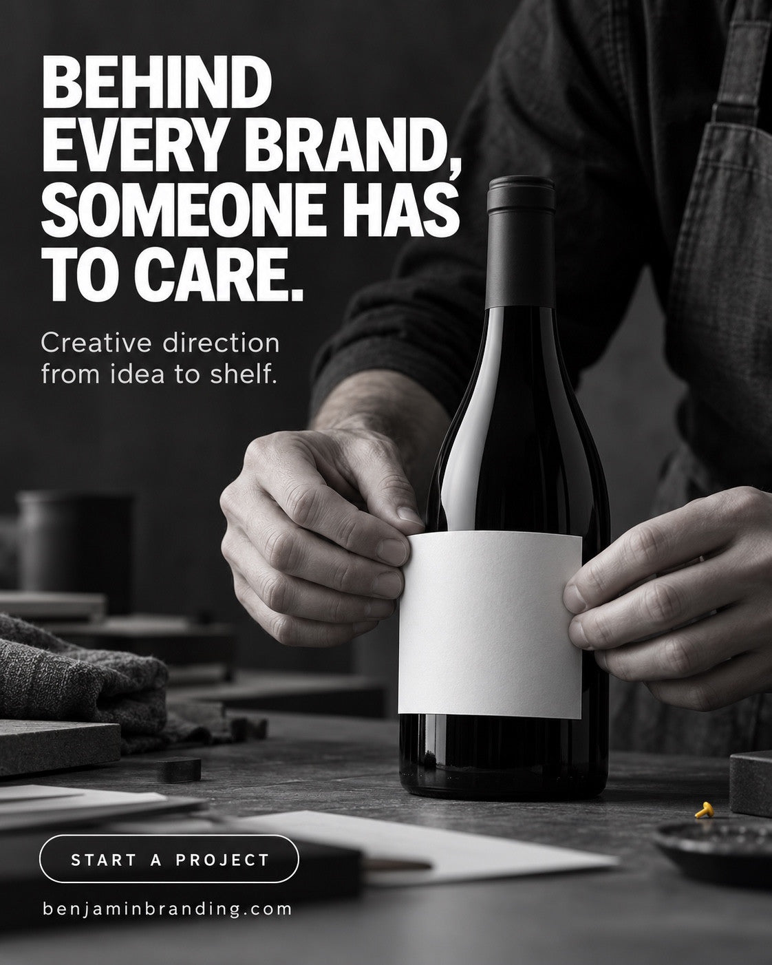 Hands positioning a blank label on a dark bottle. Benjamin Branding creative: Behind every brand, someone has to care.