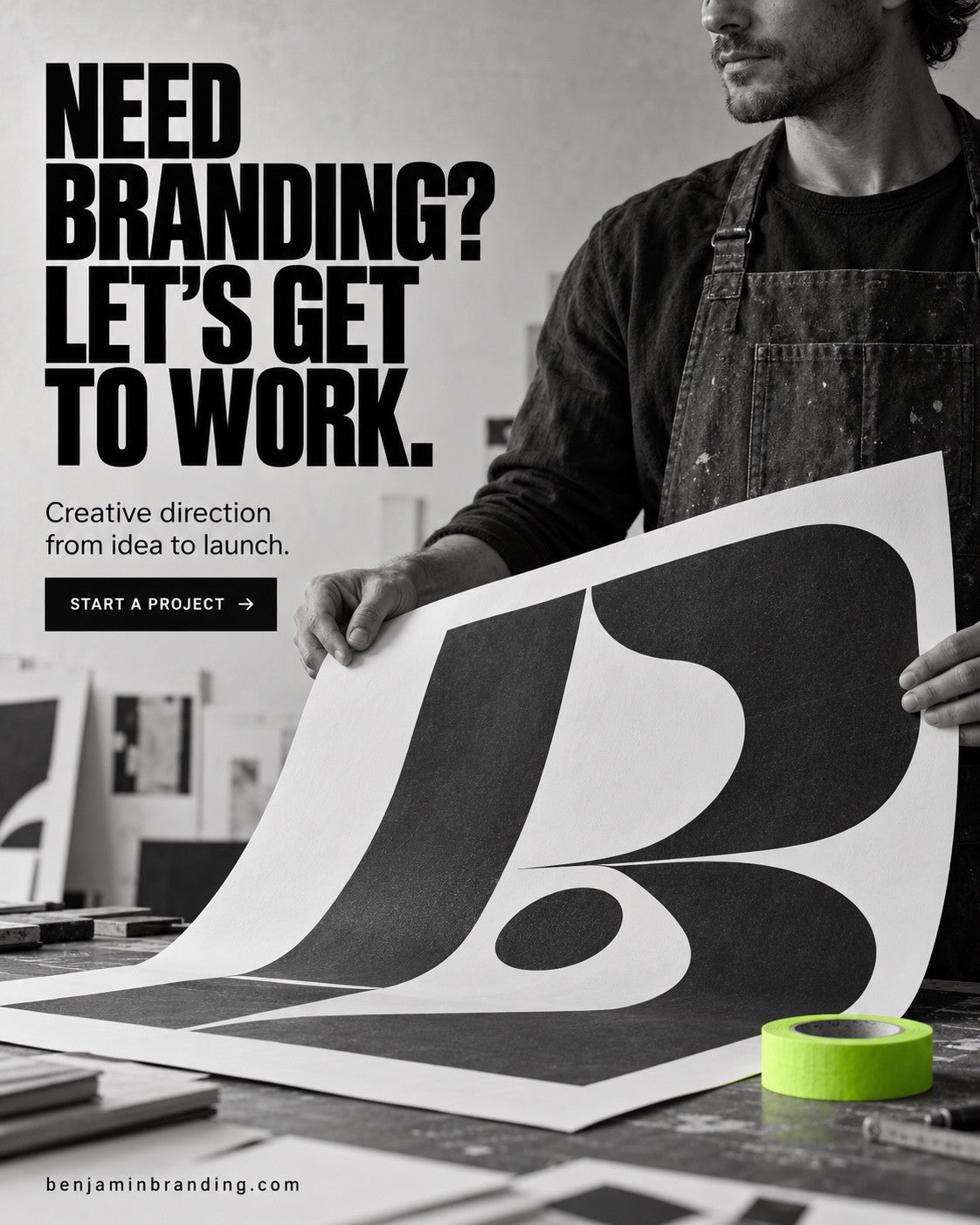 A designer holding a large black-and-white letterform print. Benjamin Branding creative: Need branding? Let’s get to work.