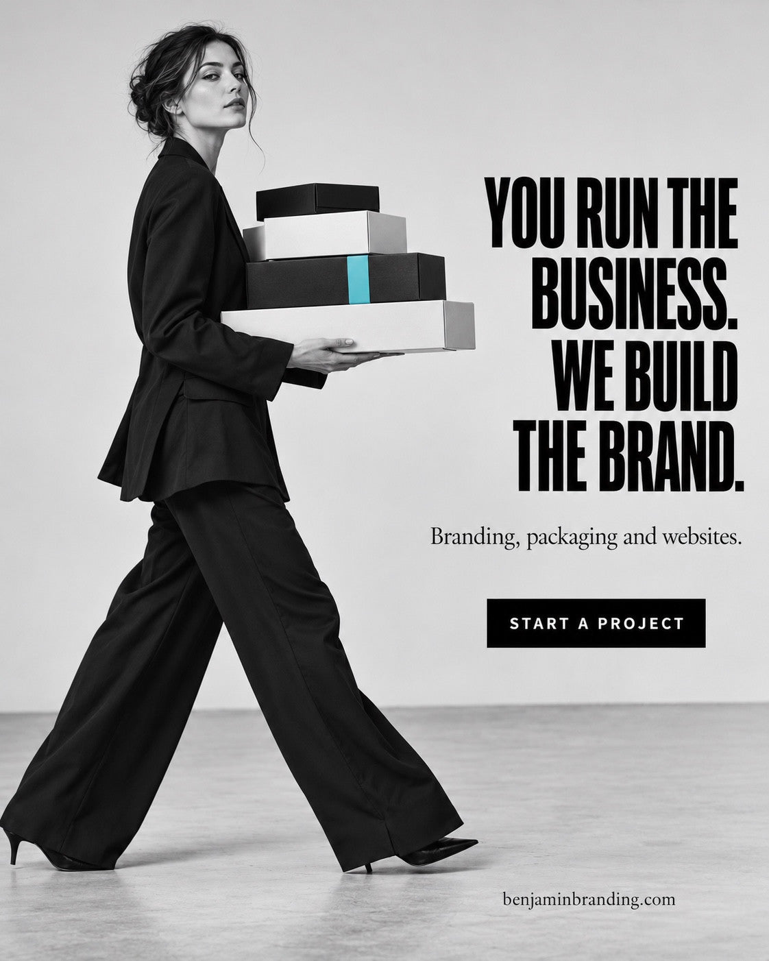 A woman carrying stacked black-and-white boxes with a turquoise accent. Benjamin Branding creative: You run the business. We build the brand.